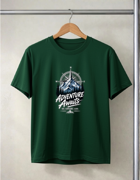A Bottle green short-sleeve t-shirt hanging on a wooden hanger against a light gray wall. The shirt features a graphic print on the chest with a mountain, compass rose, and the text 'ADVENTURE Awaits' in white and light blue.
