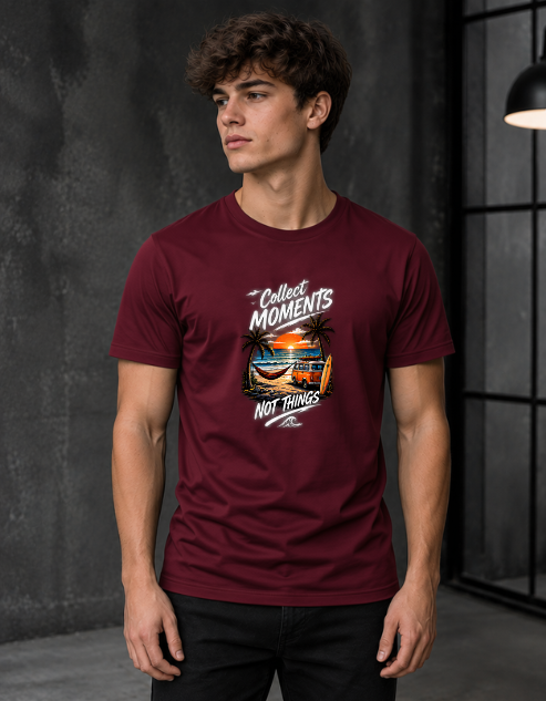 A man wearing a maroon short-sleeve graphic t-shirt with a tropical beach print and the text 'Collect Moments NOT RINGS', standing in a dark, modern room.
