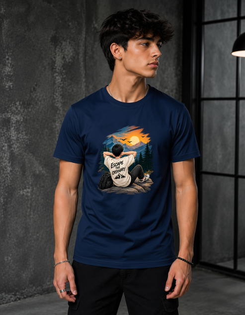 A man wearing a navy blue t-shirt with a detailed graphic print on the front, set against a dark, industrial interior background.