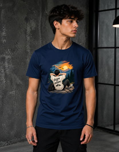 A man wearing a navy blue t-shirt with a detailed graphic print on the front, set against a dark, industrial interior background.