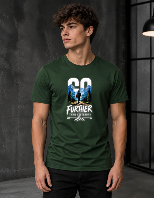 A man wearing a bottle green graphic t-shirt with a mountain and forest design and the text 'GO FURTHER THAN YESTERDAY'.