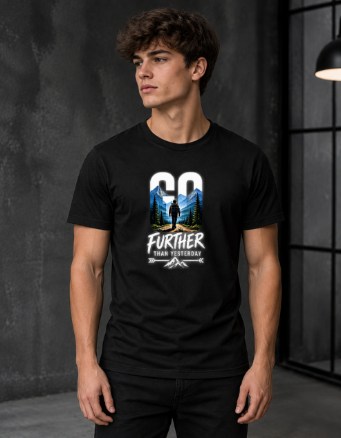 A man wearing a black short-sleeve graphic t-shirt with a mountain and tree design and the text 'GO FURTHER THAN YESTERDAY'.