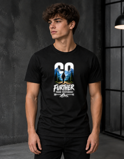 A man wearing a black short-sleeve graphic t-shirt with a mountain and tree design and the text 'GO FURTHER THAN YESTERDAY'.