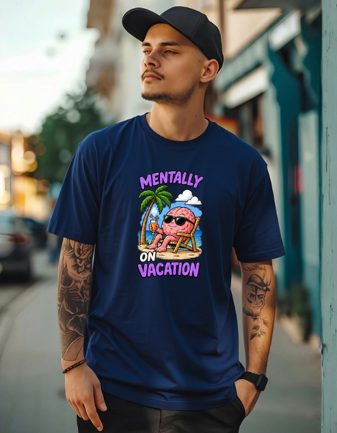 A man wearing a navy blue graphic t-shirt with a 'MENTALLY ON VACATION' cartoon design, standing on an outdoor street.