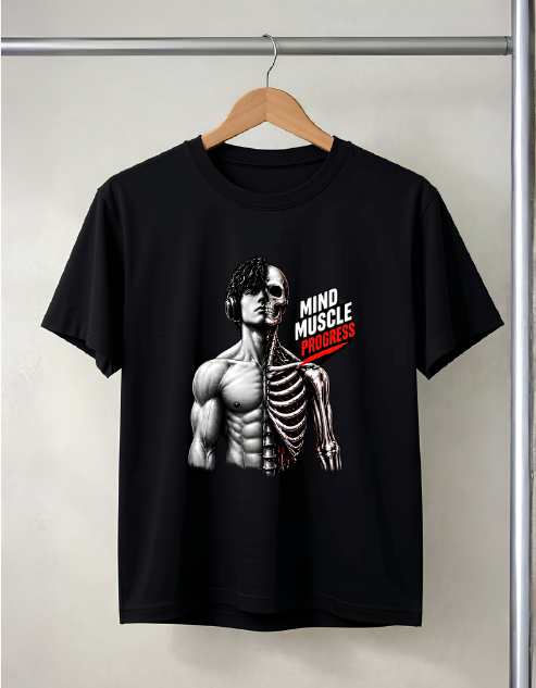 A black short-sleeve graphic t-shirt hanging on a wooden hanger against a light gray wall. The graphic features a split human figure with one half showing detailed muscle anatomy and the other half showing a skeleton, with the text 'MIND MUSCLE PROGRESS' printed in white and red.