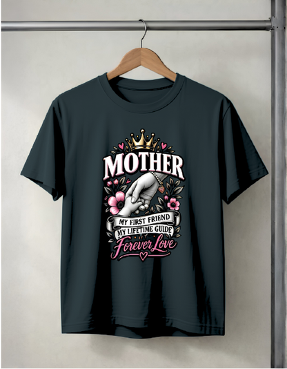 A black short-sleeve t-shirt hanging on a wooden hanger against a light gray wall. The shirt features a graphic print on the front with a crown, a hand holding a heart, flowers, and the text 'MOTHER MY FIRST FRIEND MY LIFETIME GUIDE Forever Love'.
