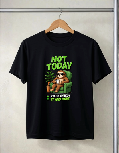 A black short-sleeve graphic t-shirt hanging on a wooden hanger against a light beige wall. The graphic features a cartoon sloth wearing sunglasses and sitting in a green armchair, with the text 'NOT TODAY' in green above and 'I'M ON ENERGY SAVING MODE' below.