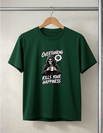 A Bottle Green short-sleeve t-shirt hanging on a wooden hanger against a light gray textured wall. The shirt features a white graphic print of a skeleton in a hoodie holding a mug, with the text 'OVERTHINKING KILLS YOUR HAPPINESS' and a small flower illustration.