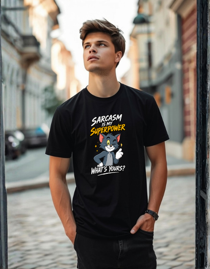 A man wearing a black graphic t-shirt with a cartoon cat and the text 'SARCASM IS MY SUPERPOWER' and 'WHAT'S YOURS?' standing in an outdoor street setting.